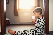 Kind im Pyjama trinkt ein Glas Milch Kind im Pyjama trinkt ein Glas Milch